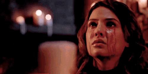 a woman is crying with blood dripping from her face .