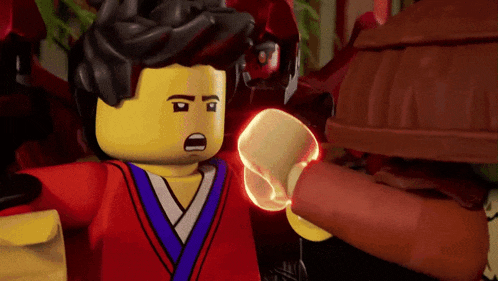 a lego ninjago character is holding a red object in his hand