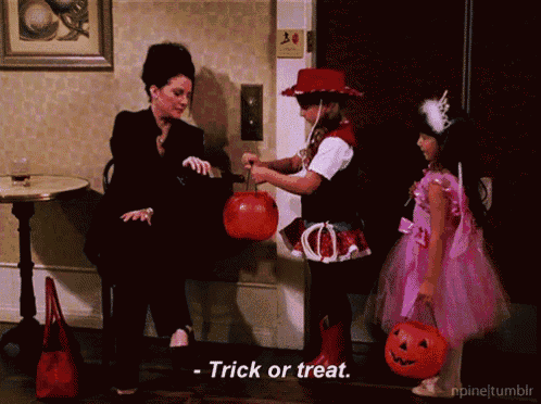 a girl in a pink dress is holding a pumpkin while a woman in a black suit says trick or treat
