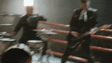a man playing drums and a man playing a guitar