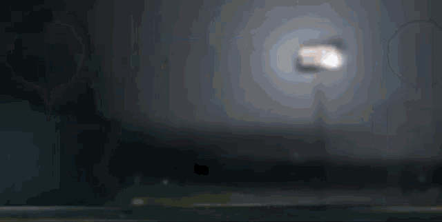 a blurred image of a light on a pole in the dark .