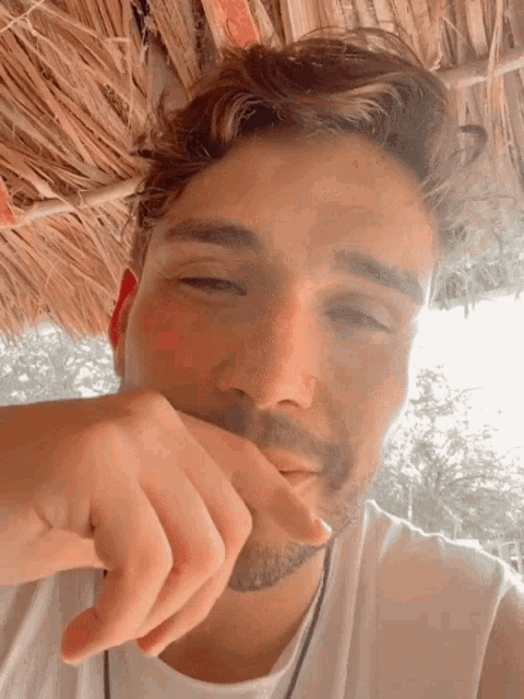 a close up of a man 's face with his hand on his chin