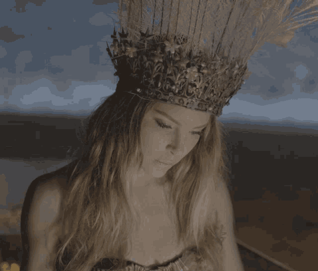 a woman with a crown on her head looks down at something