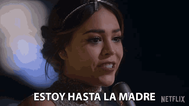 a woman singing into a microphone with the words " estoy hasta la madre " written below her