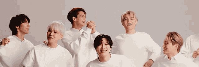 a group of young men wearing white sweaters are standing next to each other .