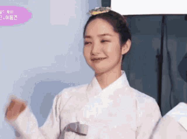 a woman in a traditional korean dress is smiling