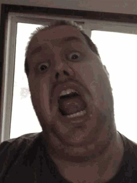 a man with a beard is making a funny face with his mouth open