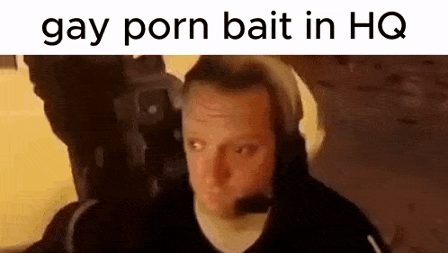 a man wearing headphones is sitting in front of a camera with the words `` gay porn bait in hq '' written above him .