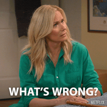 a woman in a green shirt says " what 's wrong " in white letters
