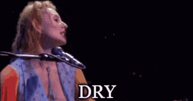 a woman singing into a microphone with the word dry written below her
