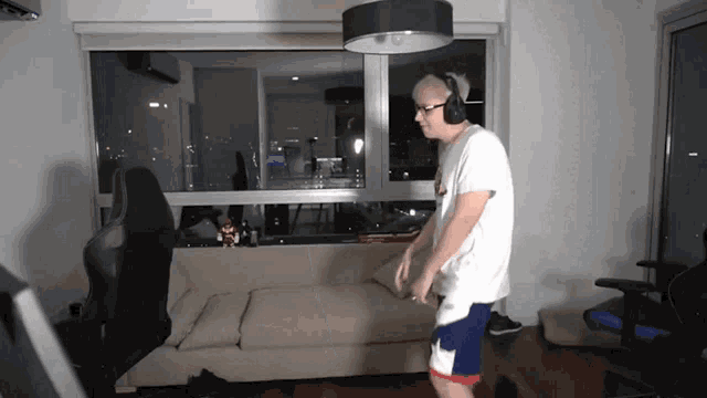 a man wearing headphones is standing in a living room