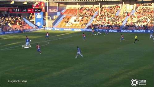 a soccer game is being played in a stadium sponsored by coca cola and abanca