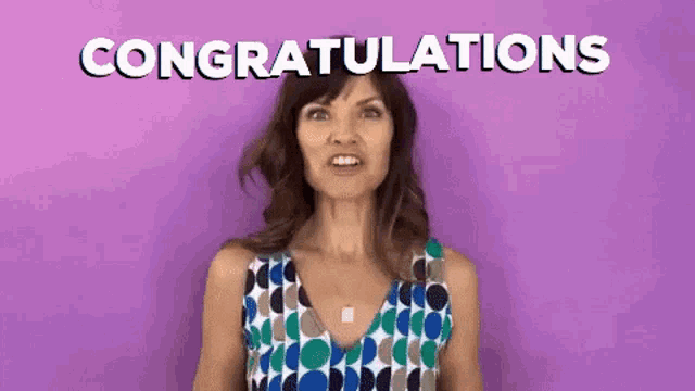 a woman in a polka dot dress is giving a congratulations gesture .
