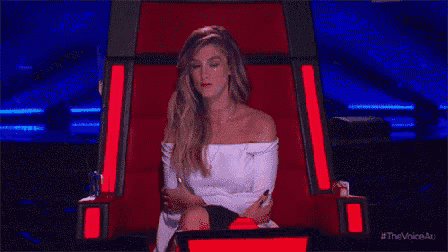 a woman is sitting in a red chair with her legs crossed and looking at the camera .