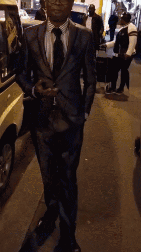 a man in a suit and tie is standing on a sidewalk