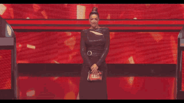 a woman in a black dress holds a piece of paper in her hands