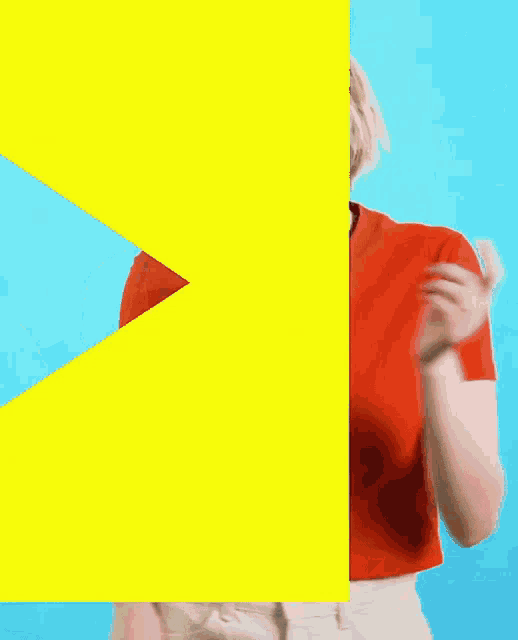 a woman in a red shirt is dancing in front of a yellow box