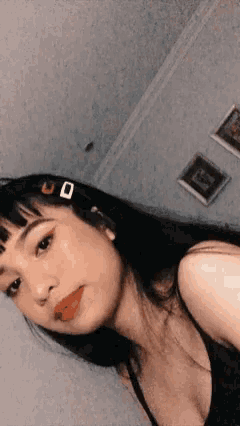 a woman taking a selfie with a clip in her hair that says u on it