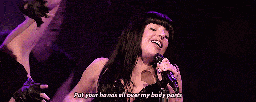 a woman is singing into a microphone with the words put your hands all over my body parts