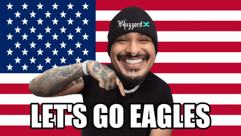 a man in front of an american flag with the words let 's go eagles below him