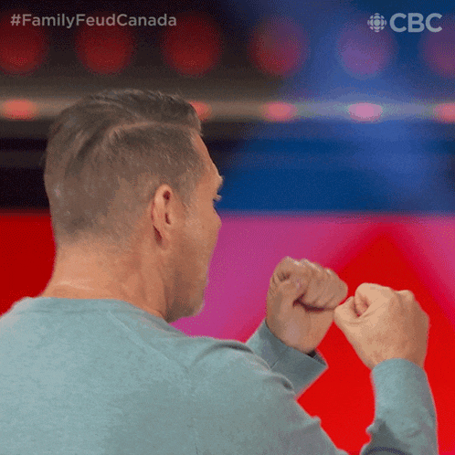 a man 's fist is raised in the air with the hashtag #familyfeudcanada
