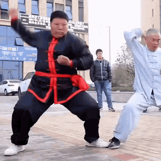 a man in a black and red outfit is dancing in front of a sign that says ' chinese ' on it