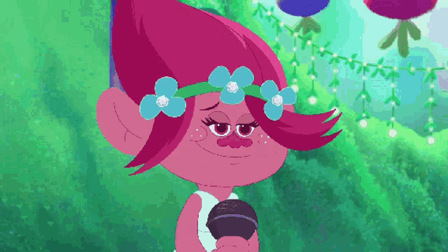 a troll with flowers in her hair is holding a microphone and smiling