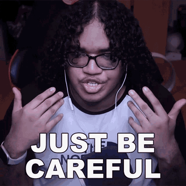 a man with curly hair is wearing glasses and headphones and says just be careful
