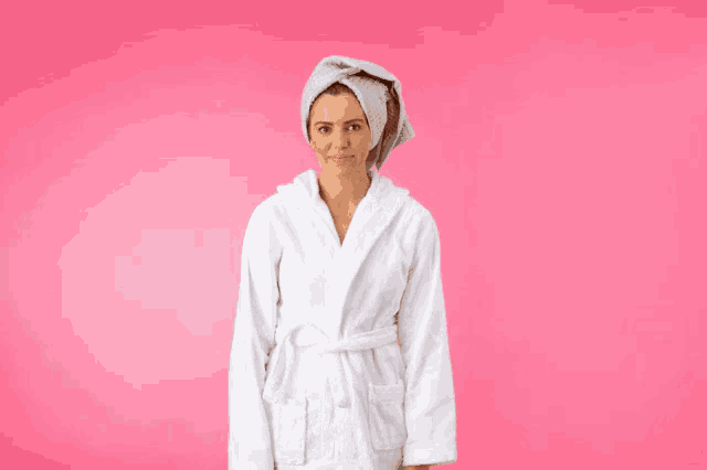 a woman in a white robe holds her hair in her hands
