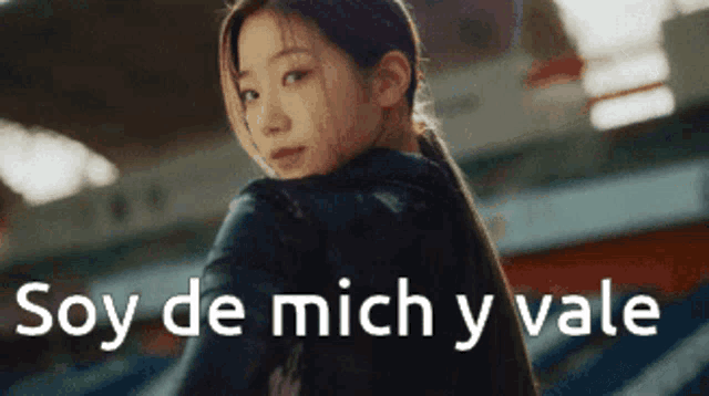 a woman is looking over her shoulder and the words soy de mich y vale are above her
