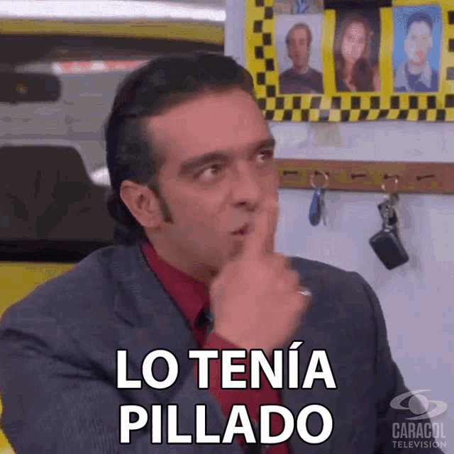 a man in a suit and red shirt is making a gesture with his finger to his mouth and says lo tenía pillado