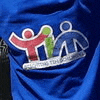 a close up of a blue shirt with a logo on the back .