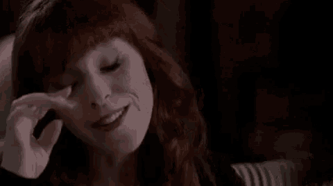a close up of a woman 's face with red hair .