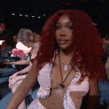 a woman with red hair is wearing a very revealing dress and necklace
