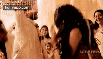 a bride and groom are dancing in front of a crowd at their wedding reception .