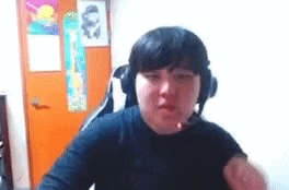a person wearing headphones and a black shirt is sitting in front of a computer screen .