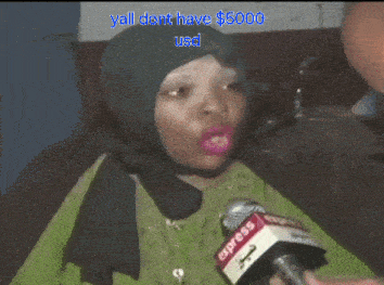 a woman wearing a hijab is being interviewed by an express news reporter