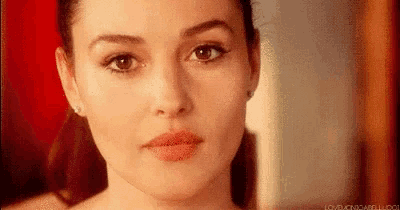 a close up of a woman 's face with a red background and a ponytail .