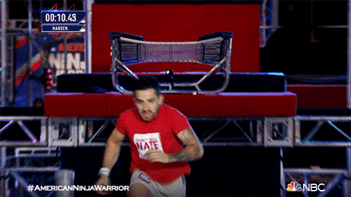 a man wearing a red shirt that says mate is running on a stage