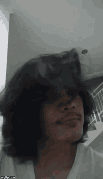 a man with long hair and a beard is smoking a cigarette