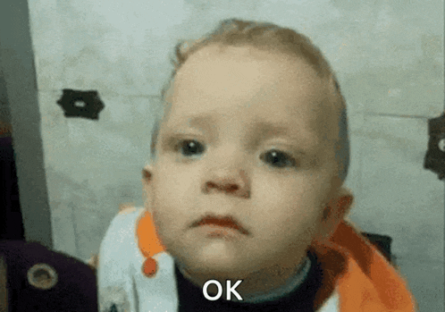 a baby is making a sad face and the word ok is on the bottom