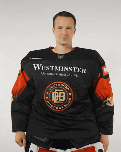 a man wearing a black and orange westminster unternehmensgruppe jersey