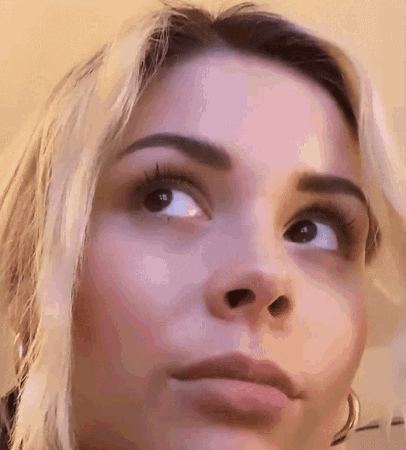 a close up of a woman 's face looking up at something