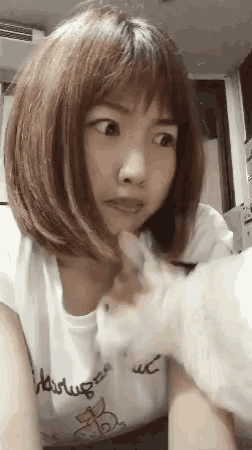 a woman wearing a white shirt that says harluga