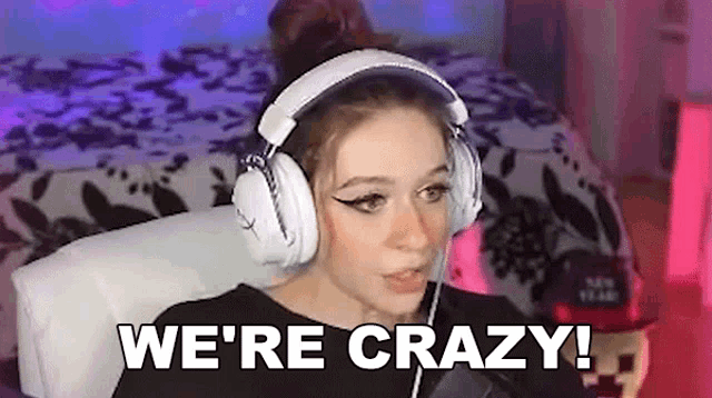 a woman wearing headphones is sitting in front of a microphone and saying `` we 're crazy ! ''