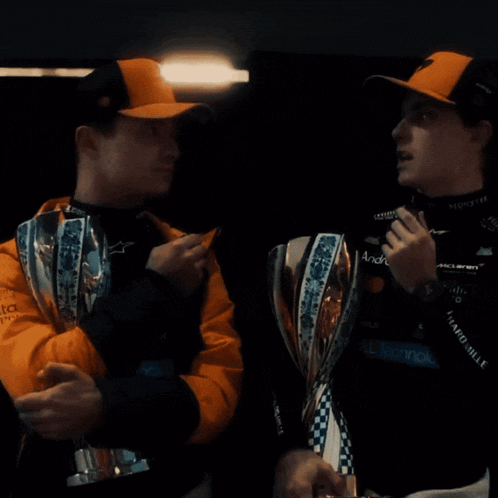 two men standing next to each other holding trophies one of which says andre
