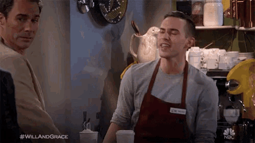 a man in an apron stands in front of a nbc advertisement