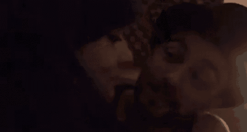 a man and woman are kissing in the dark .