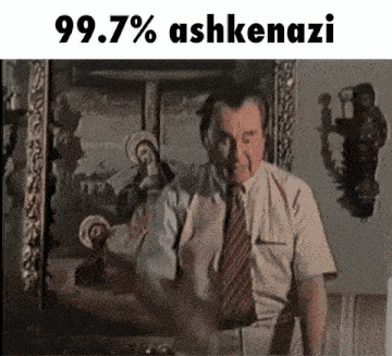 a man in a suit and tie is standing in front of a painting that says 99.7% ashkenazi on it