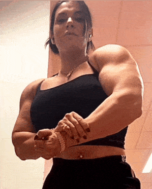 a very muscular woman wearing a black crop top with the word bewer on it